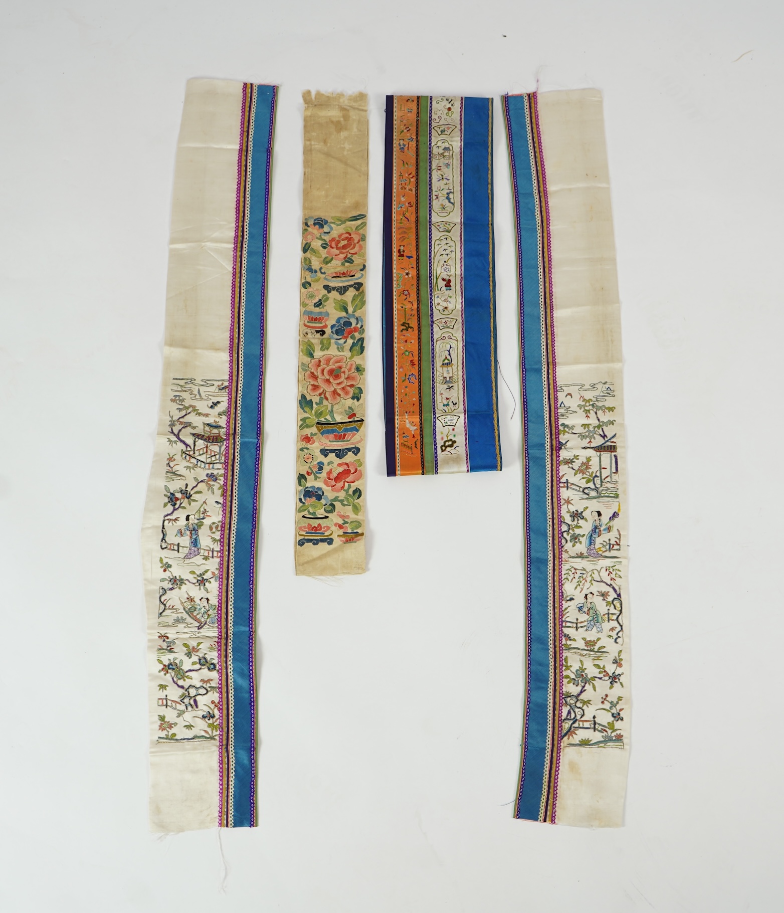 A Chinese embroidered silk panel of uncut robe borders, eleven similar sleeve panels and two other items, late Qing dynasty